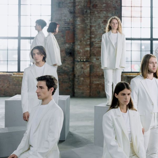 A diverse group of people sitting together on yoga mats in a bright studio.